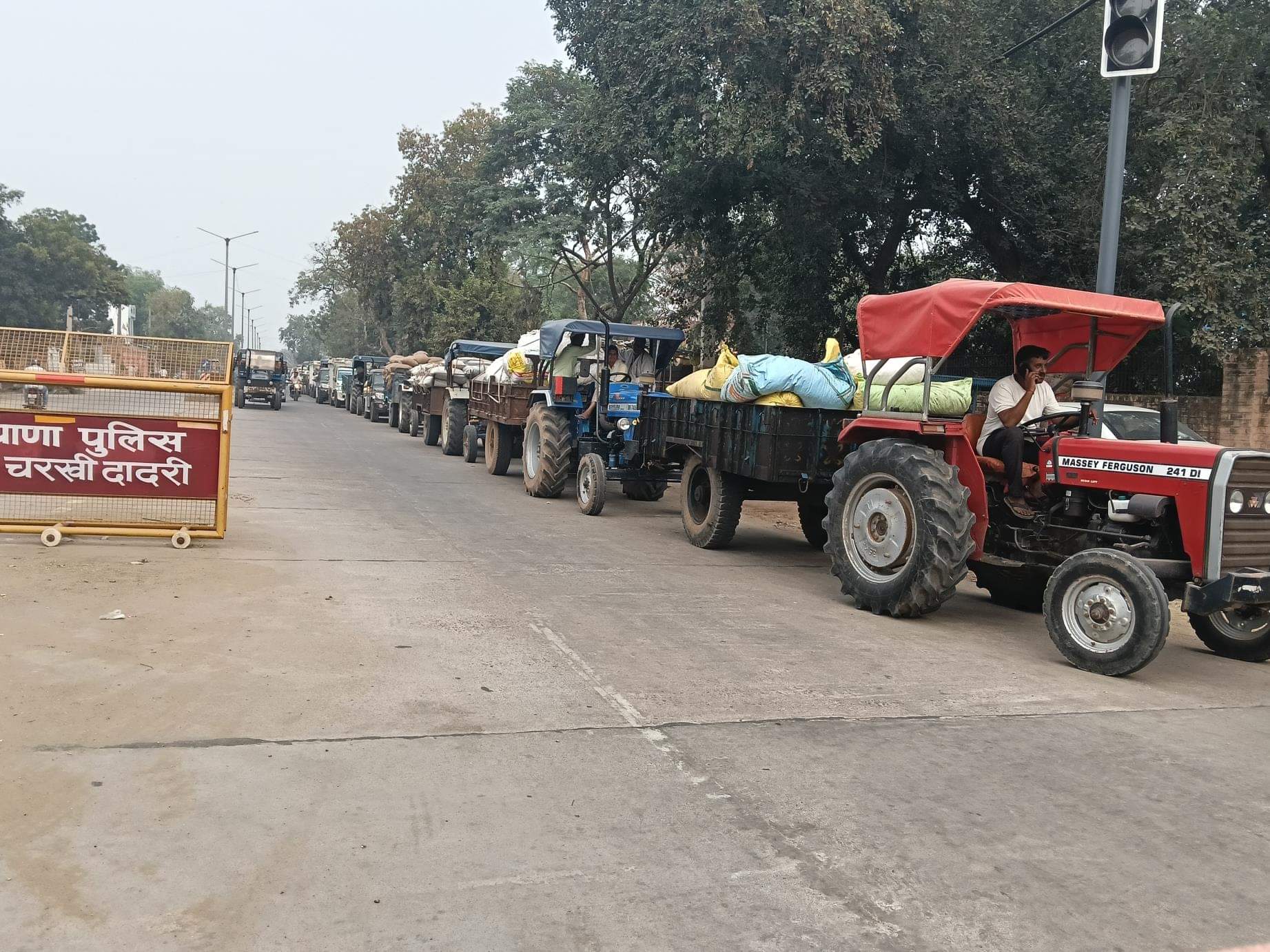 दादरी के महेंद्रगढ़ रोड पर दूर तक कतार में खड़े बाजरा से भरे ट्रैक्टर ट्राली। संवाद