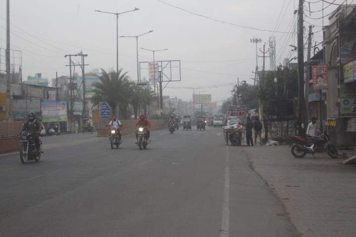 धुंध के बीच से निकलते वाहन।  