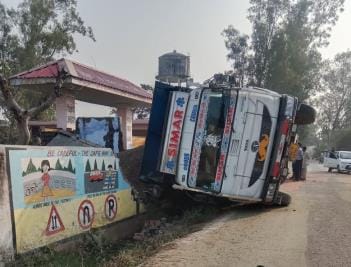 A gravel-laden tipper overturned in front of the school.