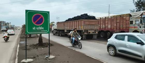Trucks line the road in Kollamandi, the no parking sign on the divider remains a mute spectator.