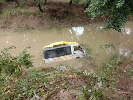 A vehicle carrying passengers overturned in a water-filled pit 20 feet below, injuring six.