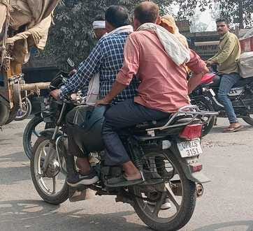 Playing with safety... carrying helmets in hand instead of wearing them on the head