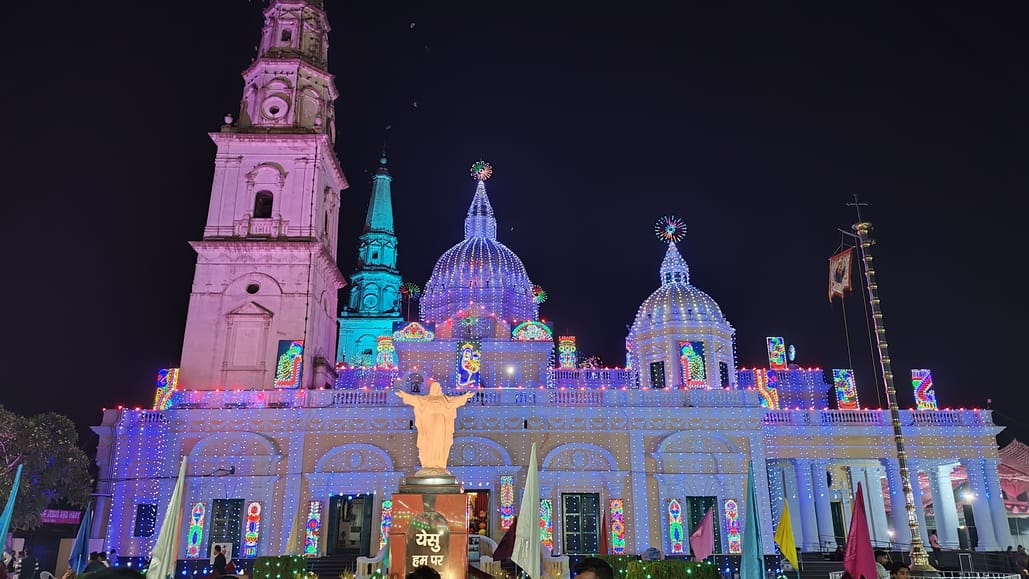 The church premises are illuminated with colorful lights.