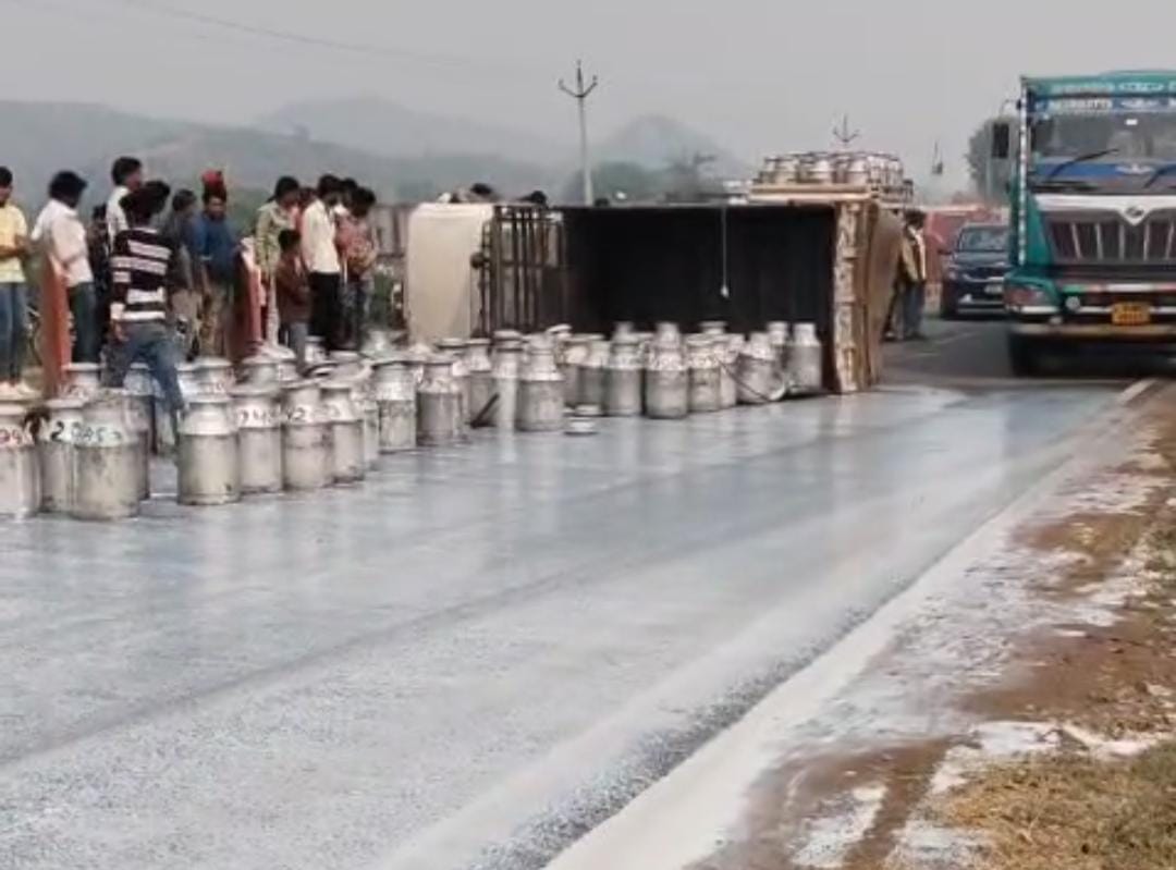 A tyre burst caused a pickup to overturn...and 55 milk drums were swept away on the highway.