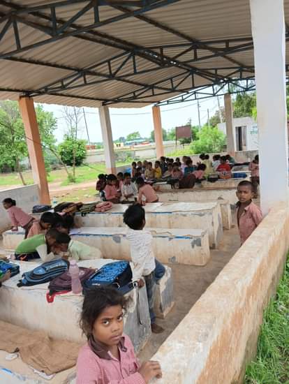 In the MDM hall of Devari Kala Primary School, young children study, and the windows are open in the hall.