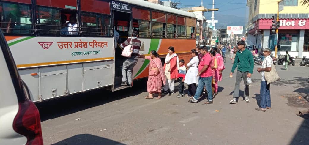 कोटद्वार के लालबत्ती चौक से ही नजीबाबाद के लिए लौटती बस में सवार होते चौक पर प्रतीक्षारत यात्री