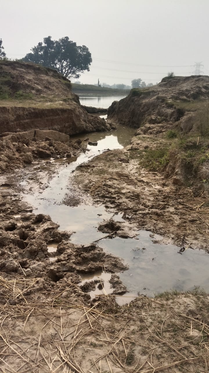 The pond's embankment broke, causing water to flow onto the road and disrupt traffic.