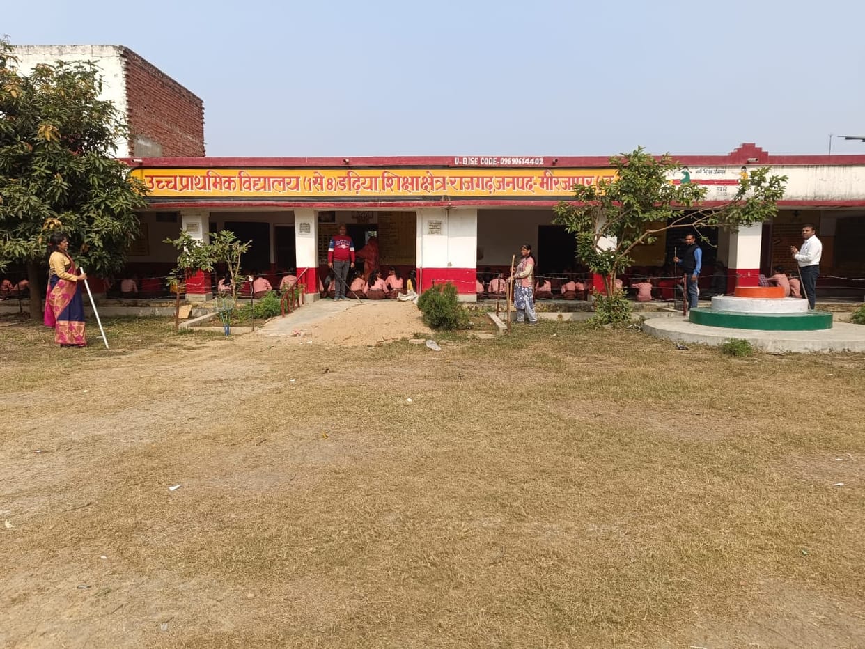 The teacher keeps watch with a stick, then the children eat.