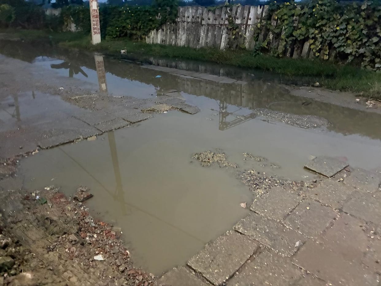 Contaminated water spread on the road due to overflow of drain on Garhi Jhanjhara Road.