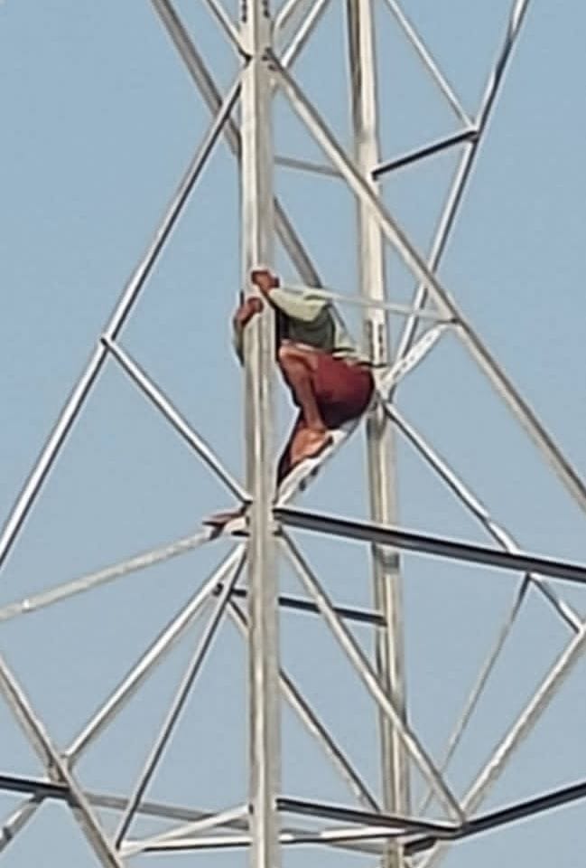 Distressed by his wife's failure to return, a young man climbed an electricity tower.