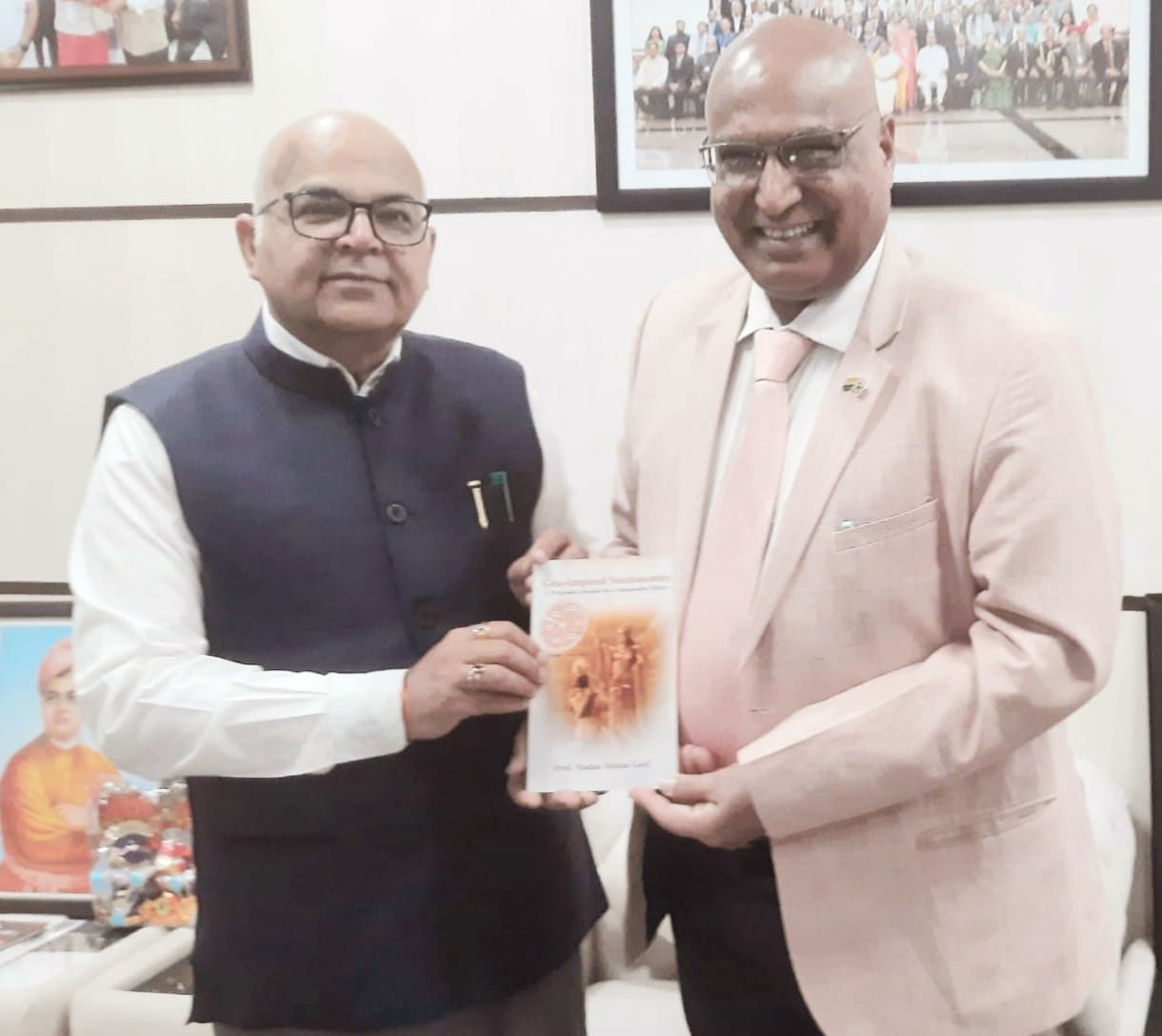 Professor Madan Mohan presented a book to the Vice Chancellor of HCW.