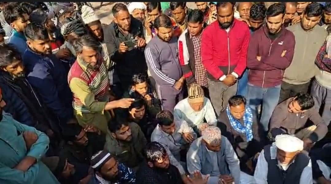 राजोरी के ख्वास मे दुकानदार की हत्या को लेकर प्रदर्शन करते लोगो को समझाते पुलिस के चौकी प्रभारी