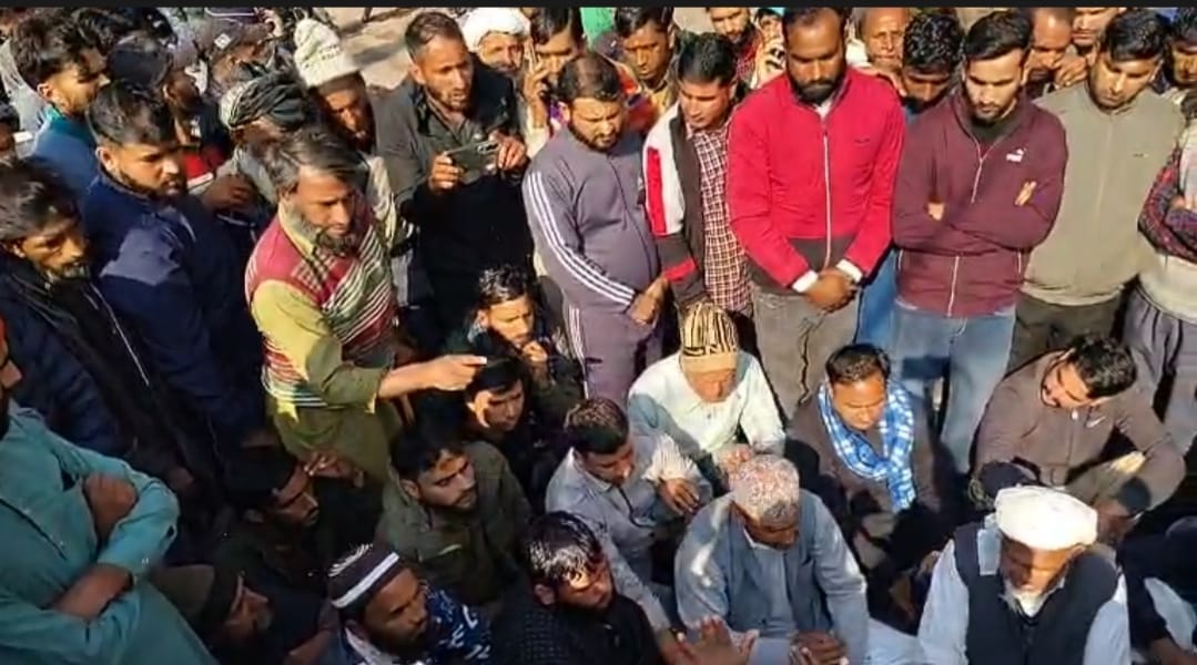 राजोरी के ख्वास मे दुकानदार की हत्या को लेकर प्रदर्शन करते लोगो को समझाते पुलिस के चौकी प्रभारी