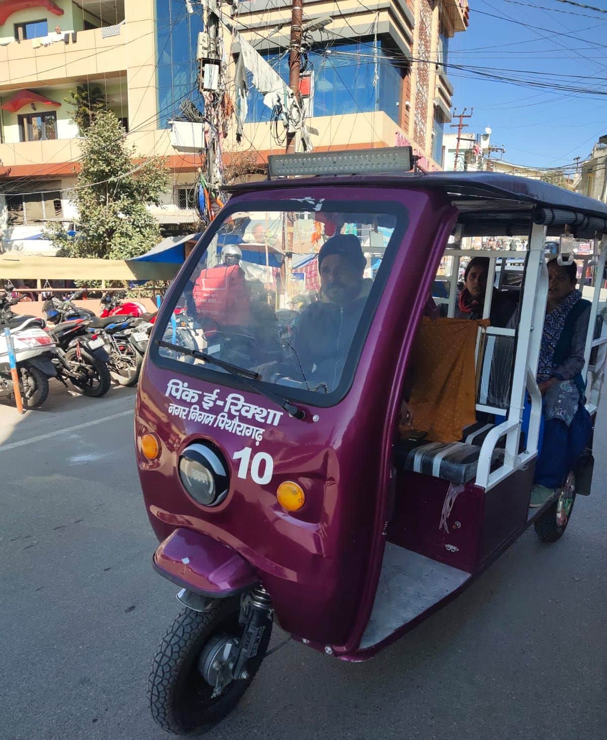 पिथौरागढ़ नगर में बगैर पंजीकरण और नंबर प्लेट के दौड़ता ई-रिक्शा और इसमें सवार यात्री। संवाद