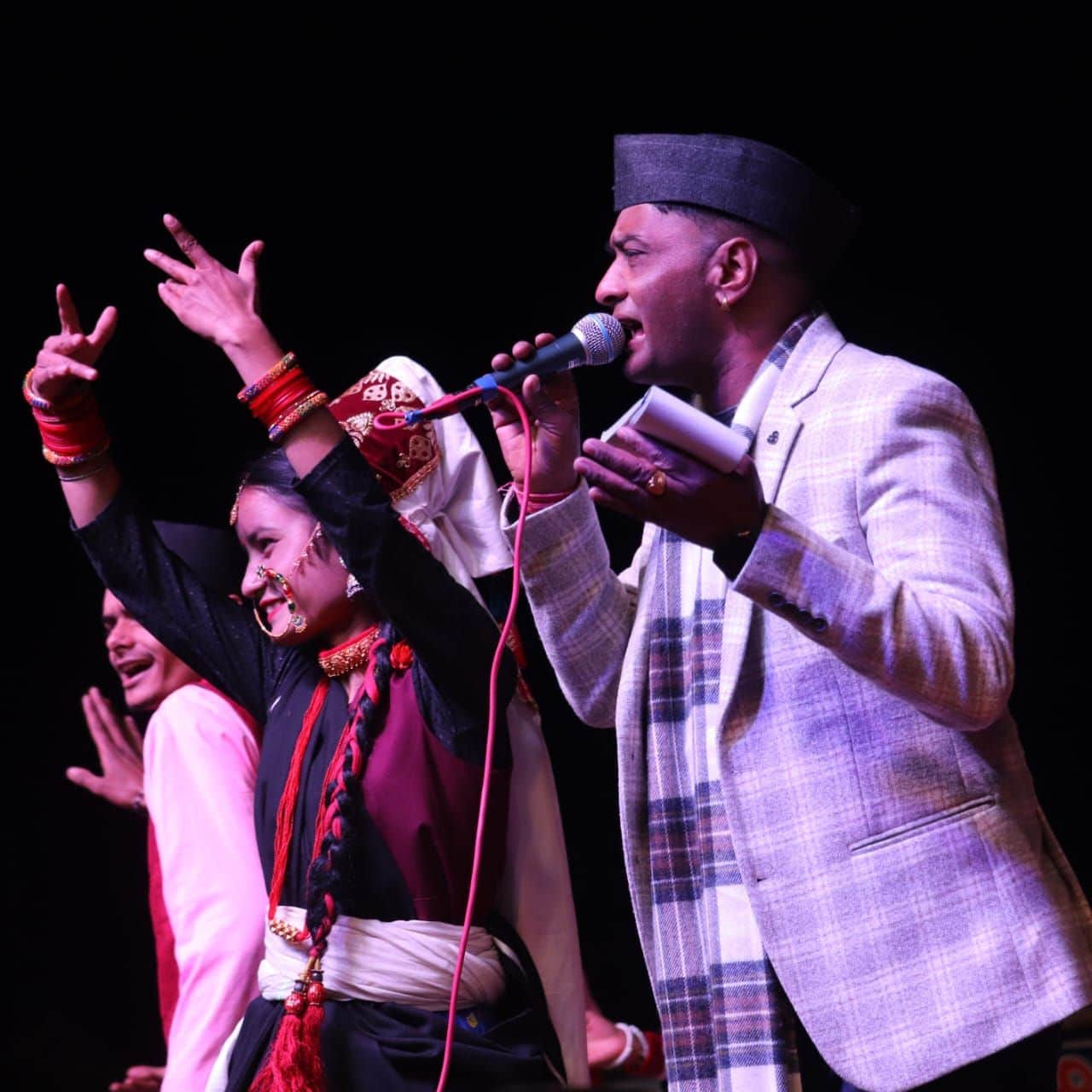 मुनस्यारी महोत्सव में गीत प्रस्तुत करते लोकगायक ललित मोहन जोशी और नृत्य करते कलाकार। संवाद