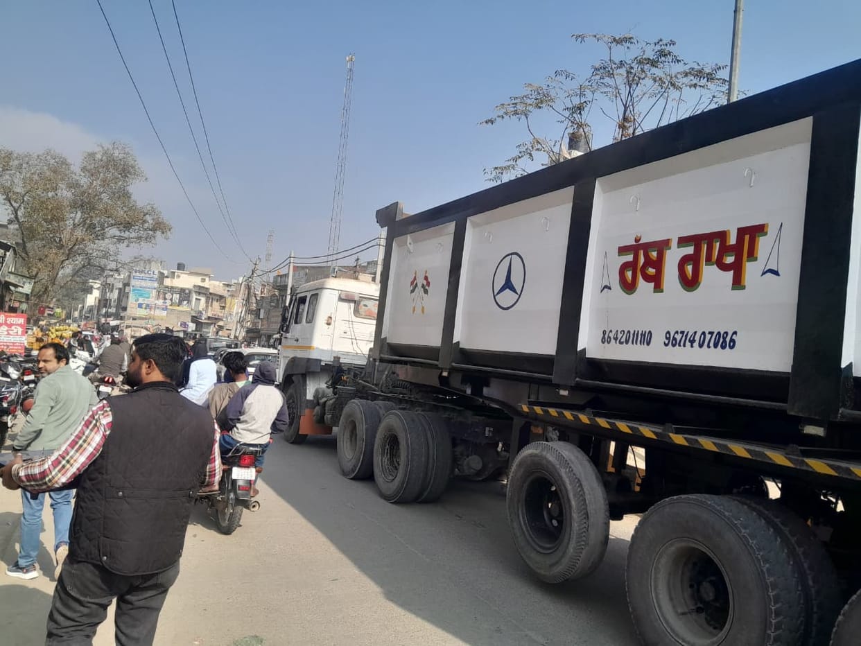 Uncovered trucks and dumpers, loaded with soil, are speeding along, and the rules are being disregarded amidst the dust