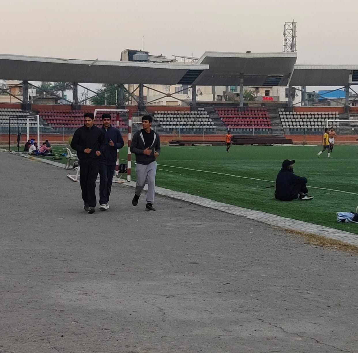 Two government swimming pools waiting for tender, players running on unfinished track