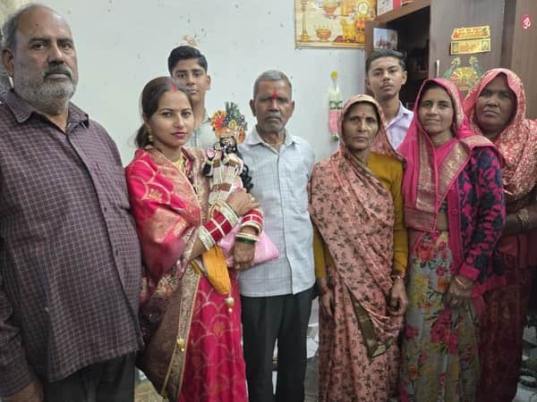 भगवान बांके बिहारी को गोद में लिए पिंकी शर्मा अपने परिजनो के साथ। संवाद