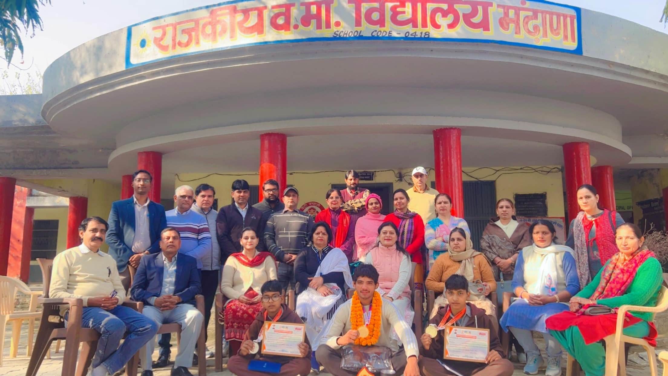 कुश्ती में पदक विजेता खिलाड़ियों का स्वागत करते स्कूल स्टाफ सदस्य।