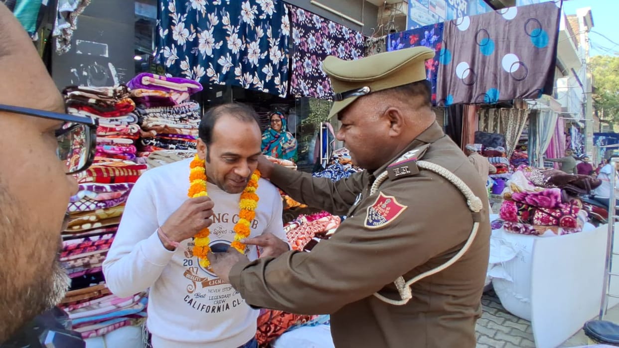 The SHO garlanded shopkeepers who had placed their goods on the sidewalk, then requested them to remove their goods
