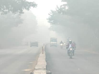 Fog engulfs the air, affecting traffic on the highway