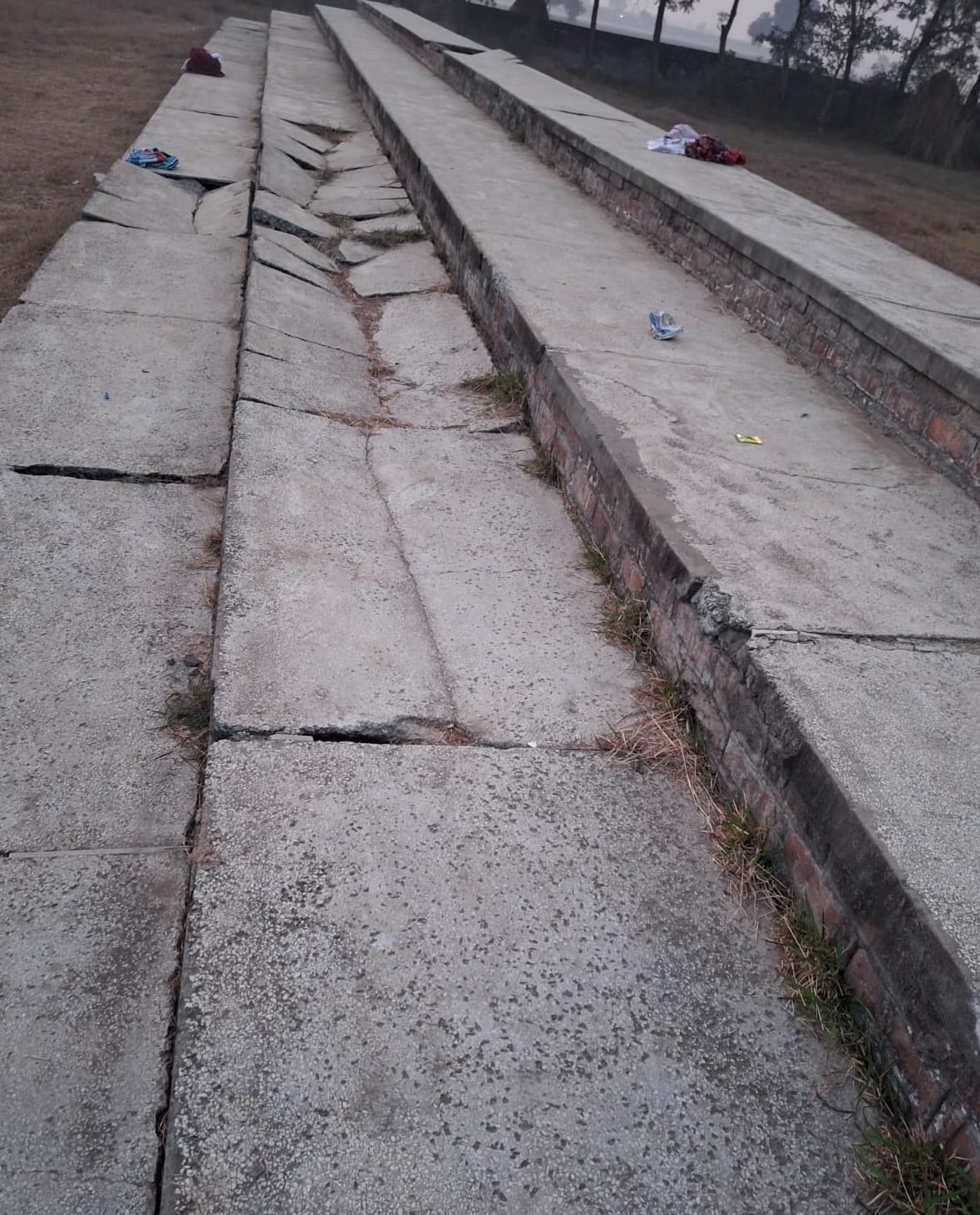 Broken glass and uprooted football track at Khaira village sports stadium