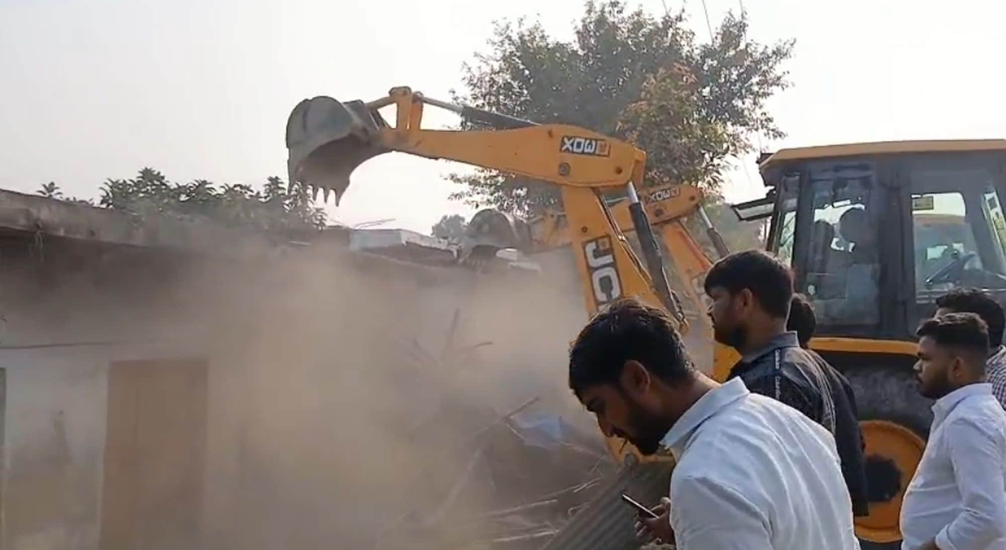अकबरपुर-टांडा मार्ग के अरिया में मकान ध्वस्त करती जेसीबी मशीन
