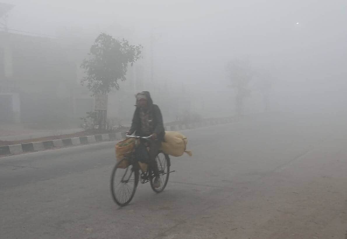 कोहरे के बीच आवागमन करते लोग। - संवाद 