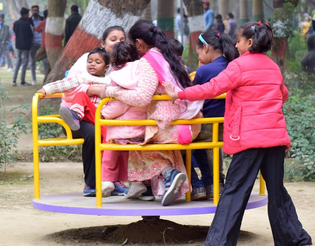 धूप निकलने पर पार्क में खेलते बच्चे।