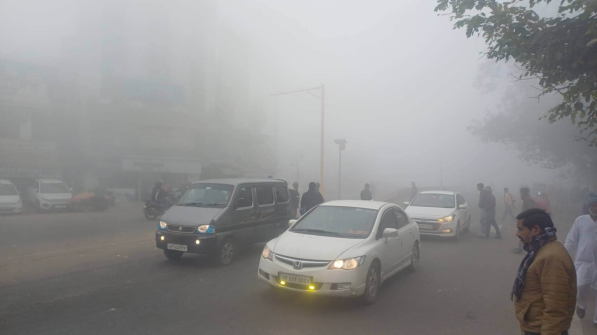 बागपत के राष्ट्र वंदना चौक पर कोहरे के बीच हाईवे पर लाइट जलाकर जाते वाहन चालक। संवाद