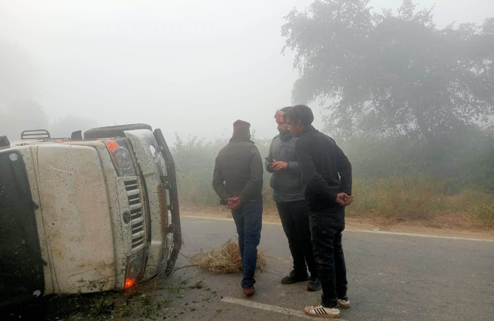 हाईवे पर पलटी पिकअप को देखते लोग। संवाद