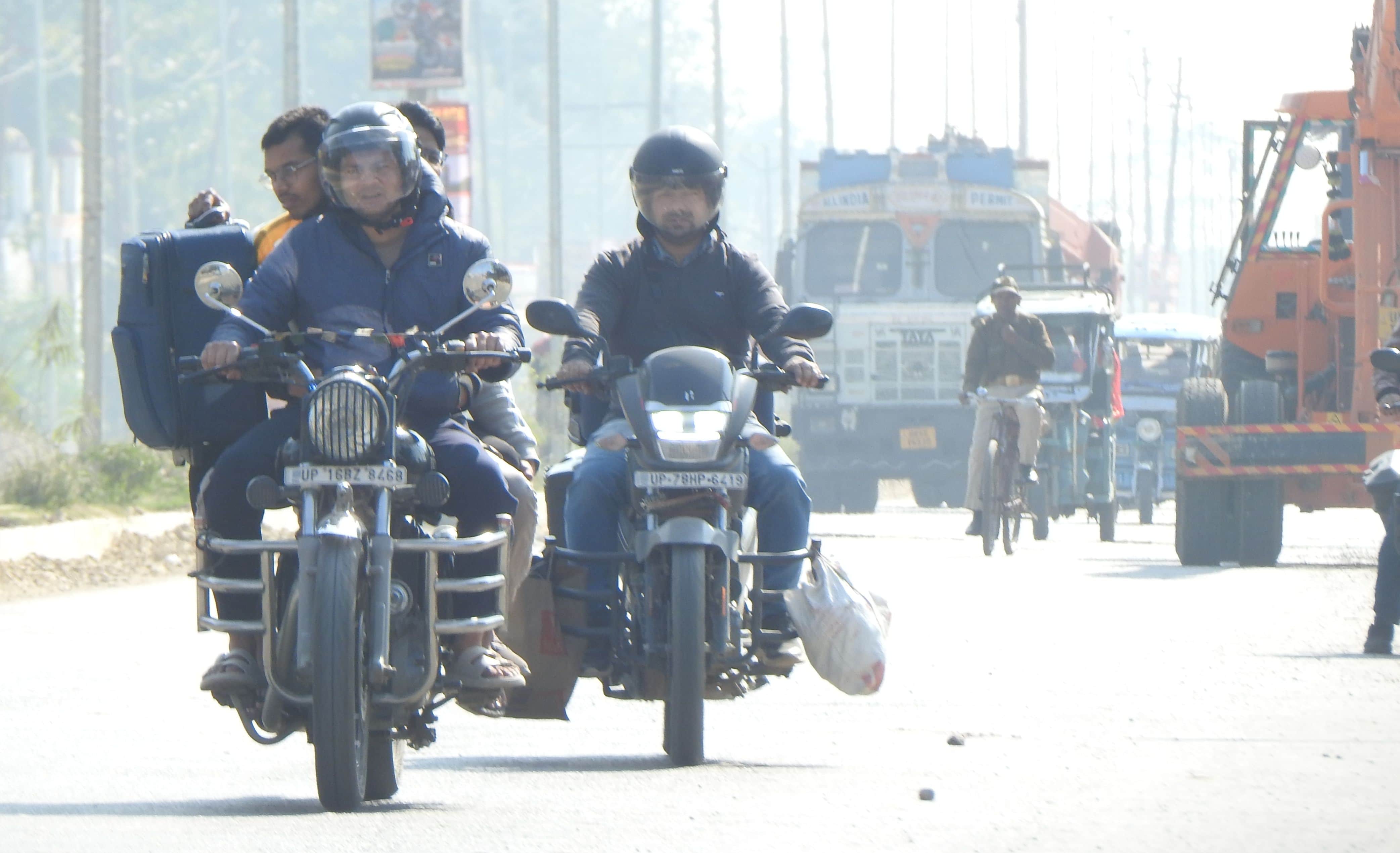 शहर के अशोक मार्ग पर दोपहर के तेज धूप के दौरान आवागमन करते लोग। संवाद