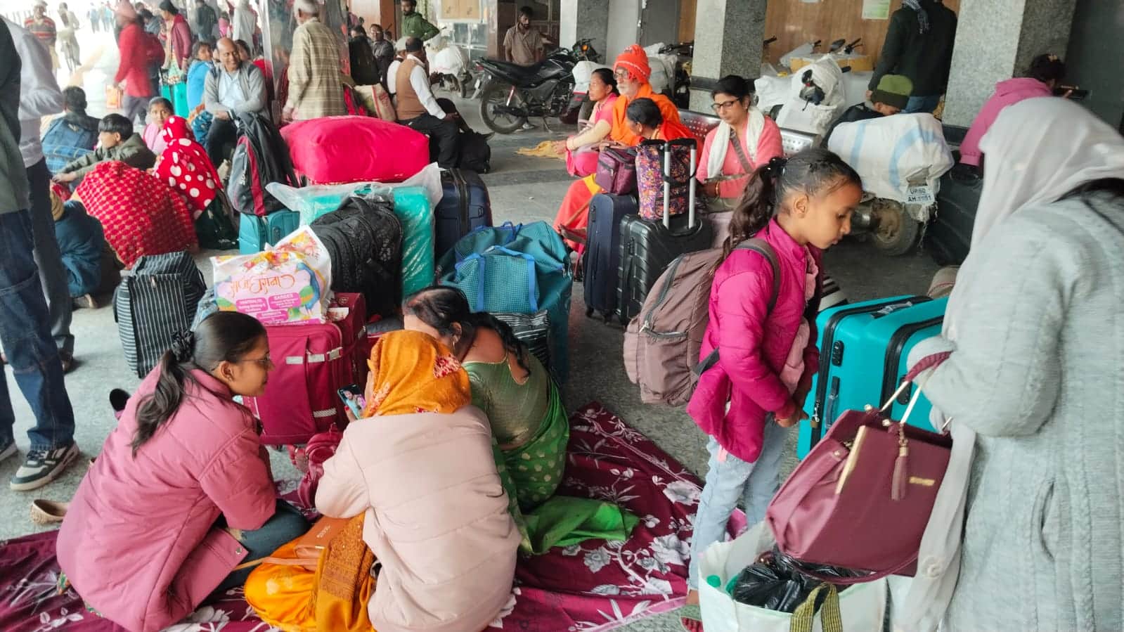 ट्रेनों के इंतजार में प्लेटफार्म पर बैठे यात्री।संवाद