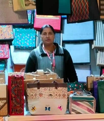 18...प्रदर्शनी में सजाए गए बैग दिखाती महिला आशा। स्रोत : समूह