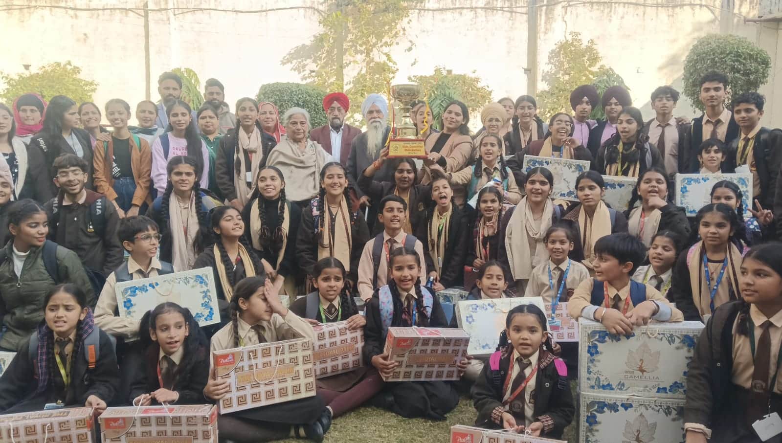 बाल महोत्सव की ट्रॉफी के साथ विद्यार्थी। 