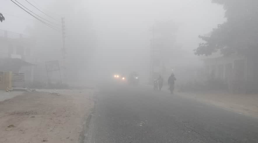 शहर में अलीगंज रोड पर सुबह के समय छाए कोहरे के बीच से निकलते वाहन व लोग। संवाद