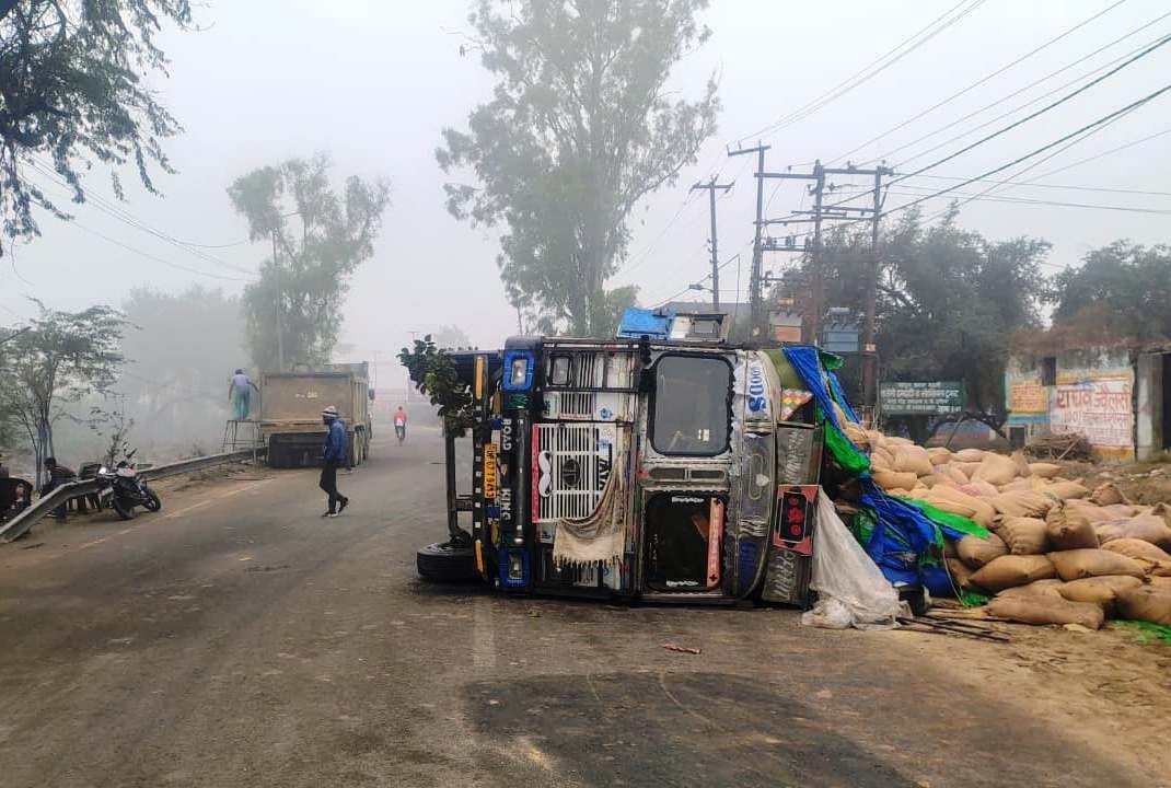 A truck loaded with millet overturned in dense fog, two injured.