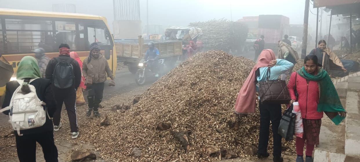 A trolley full of sawdust overturned in a pothole on the road, causing a massive traffic jam on the Hapur road.