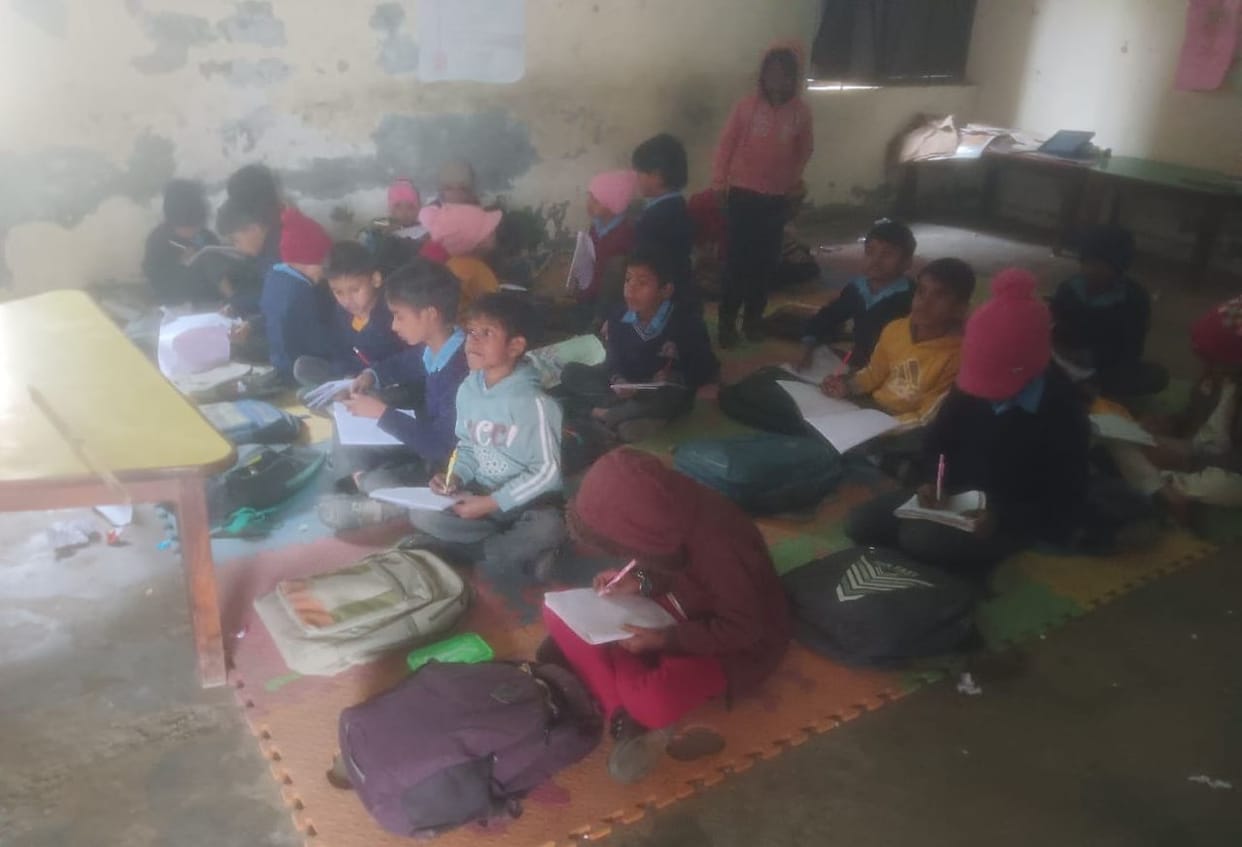 Students studying while sitting on mats, there is no electricity in the school