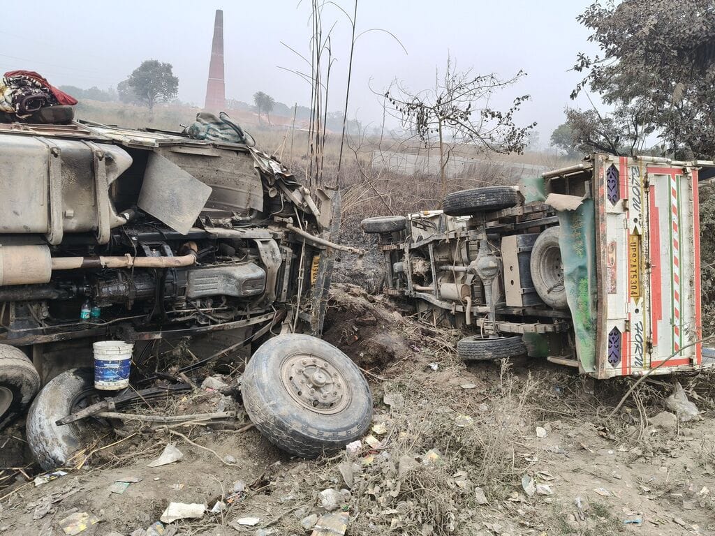 A truck loaded with gravel overturned after hitting a loader, injuring the driver.