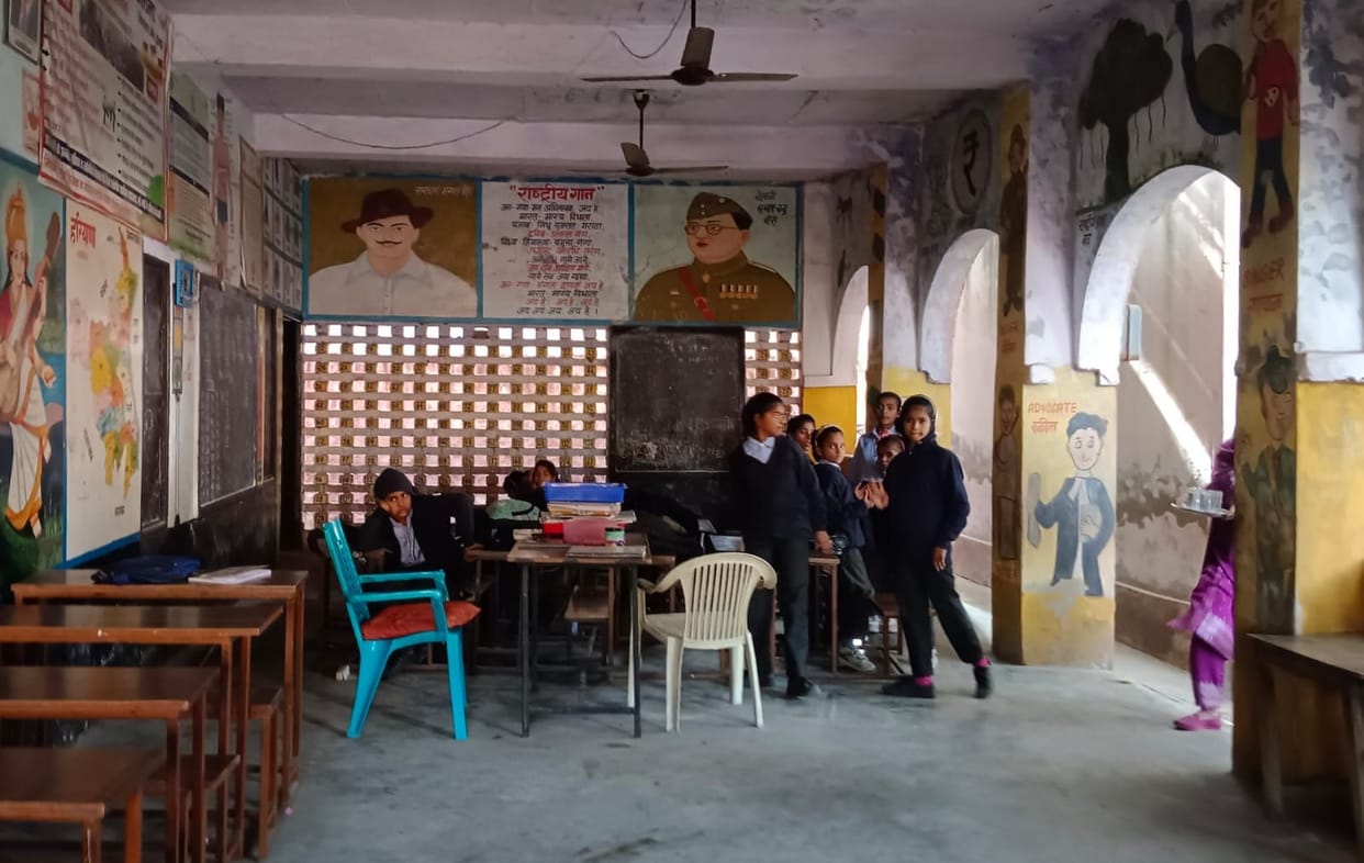 Due to a shortage of rooms, the children are sitting in the verandah.