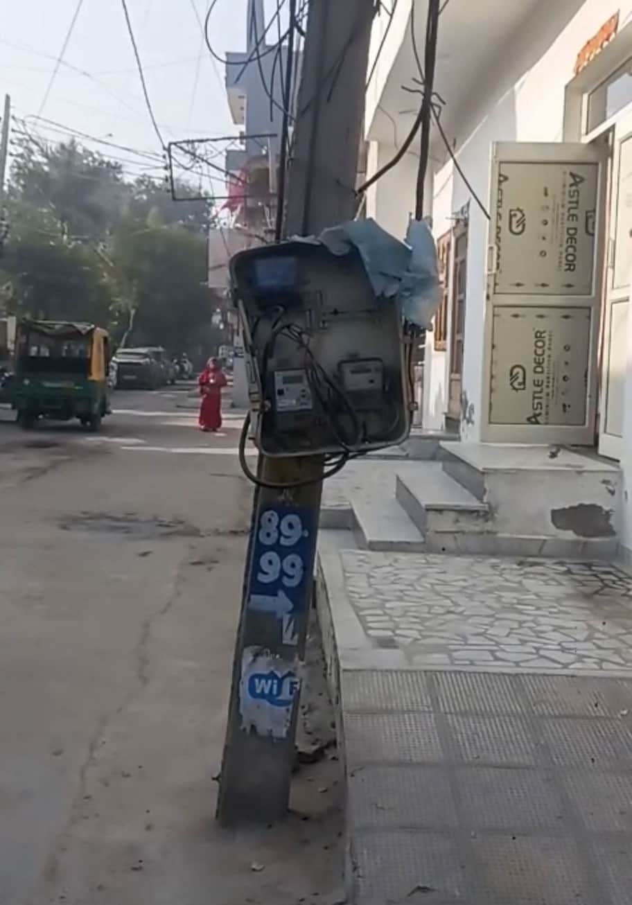 2.. कन्हेली रोड के नजदीक आंबेडकर कॉलोनी में खंभे पर लगा खुला मीटर व लटकी तार। संवाद