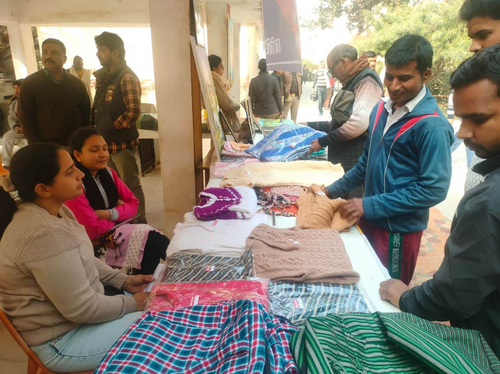 कोर्ट परिसर में लगी प्रदर्शिनी में लगे स्टॉल पर स्वेटर खरीद करते लोग। संवाद