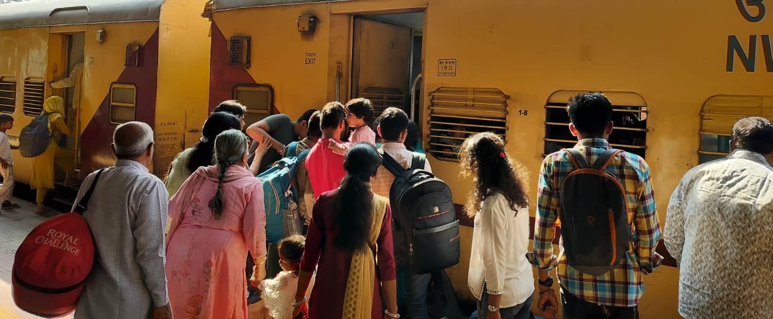 रेलवे स्टेशन पर ट्रेन में सवार होते यात्री।