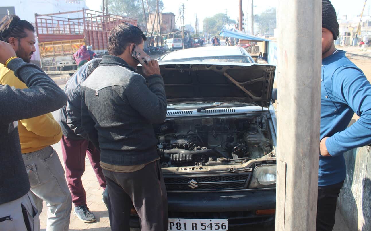 बिजली कॉटन मिल चौराहे पर चलती कार में आग लगने के बाद देखते लोग। संवाद