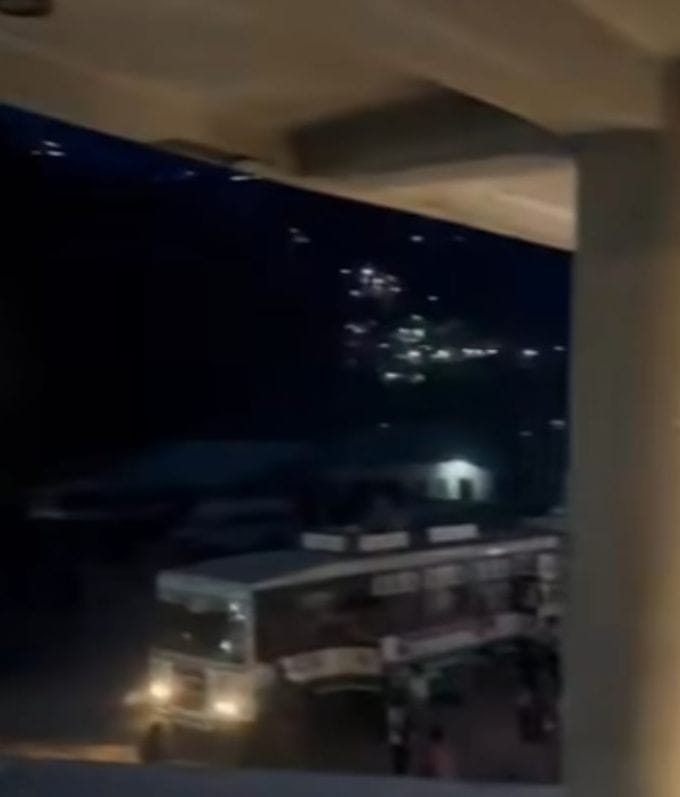 The streetlights are out of order, leaving the bus stand in darkness as the evening approaches.