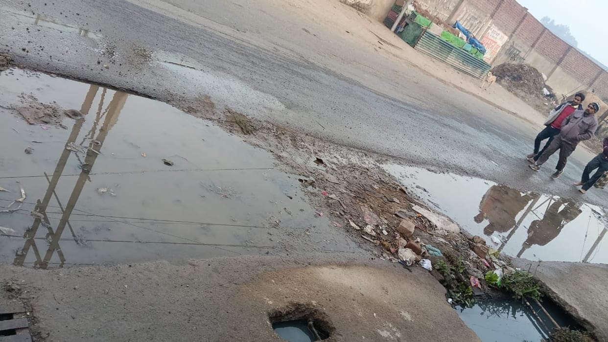 Dirty water flowing on the road due to blockage of drain in Jhadmajri