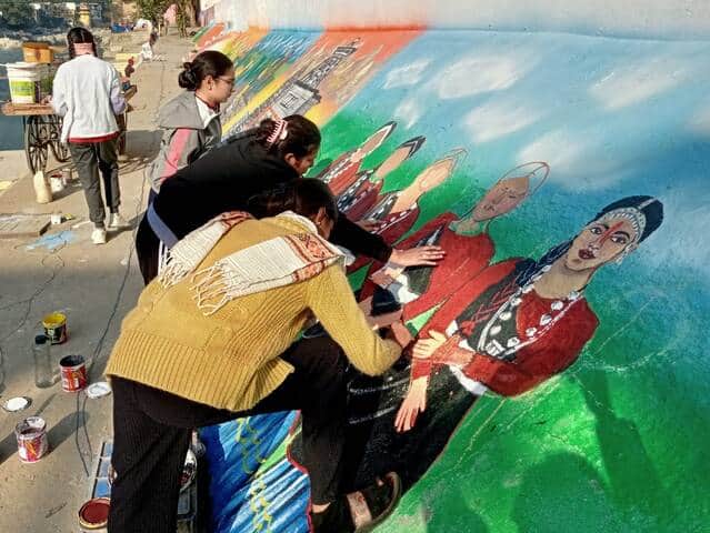 बागेश्वर के सरयू घाटों के किनारे चित्र उकेरते कलाकार। संवाद