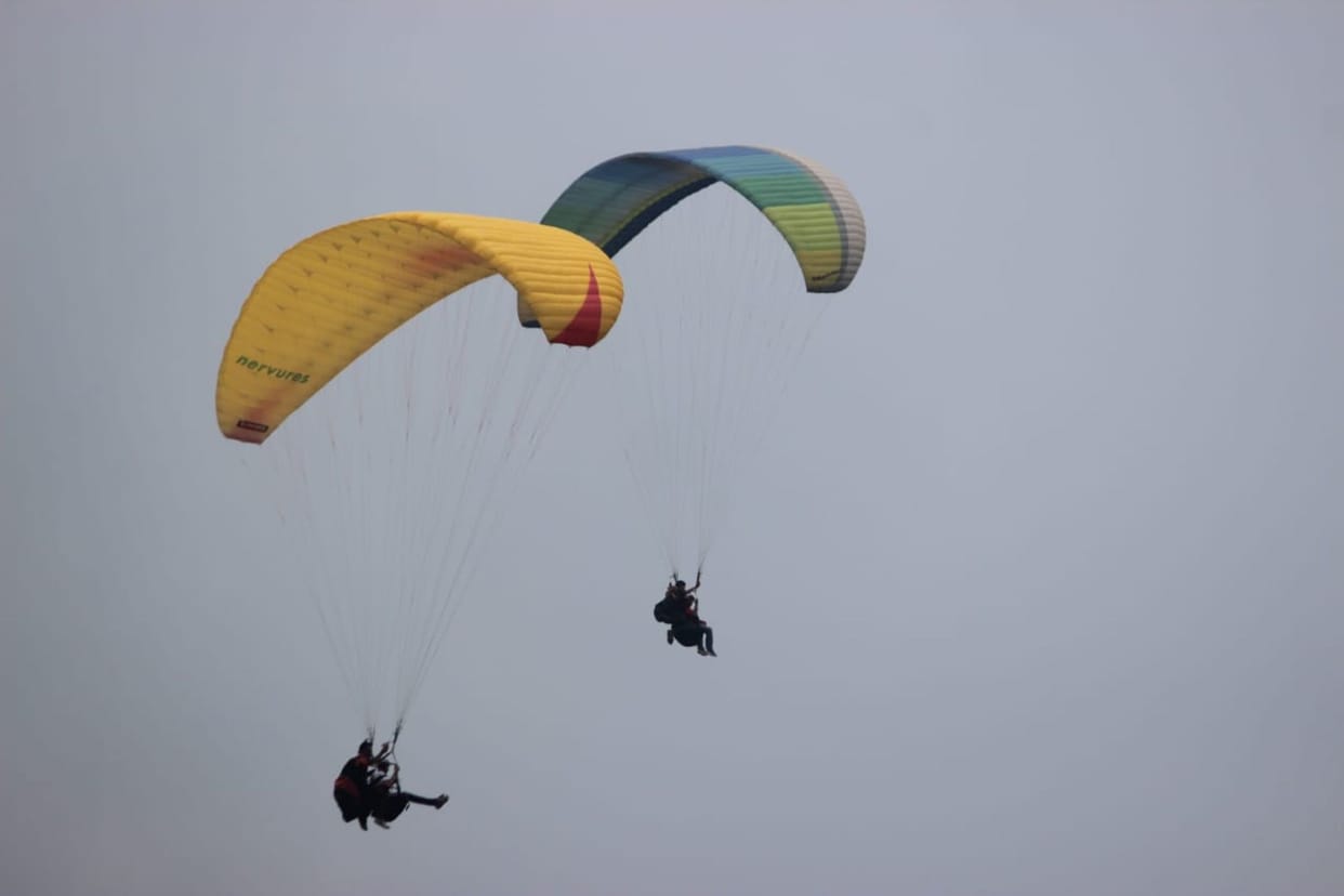After snowfall, the weather cleared and tourists went paragliding.