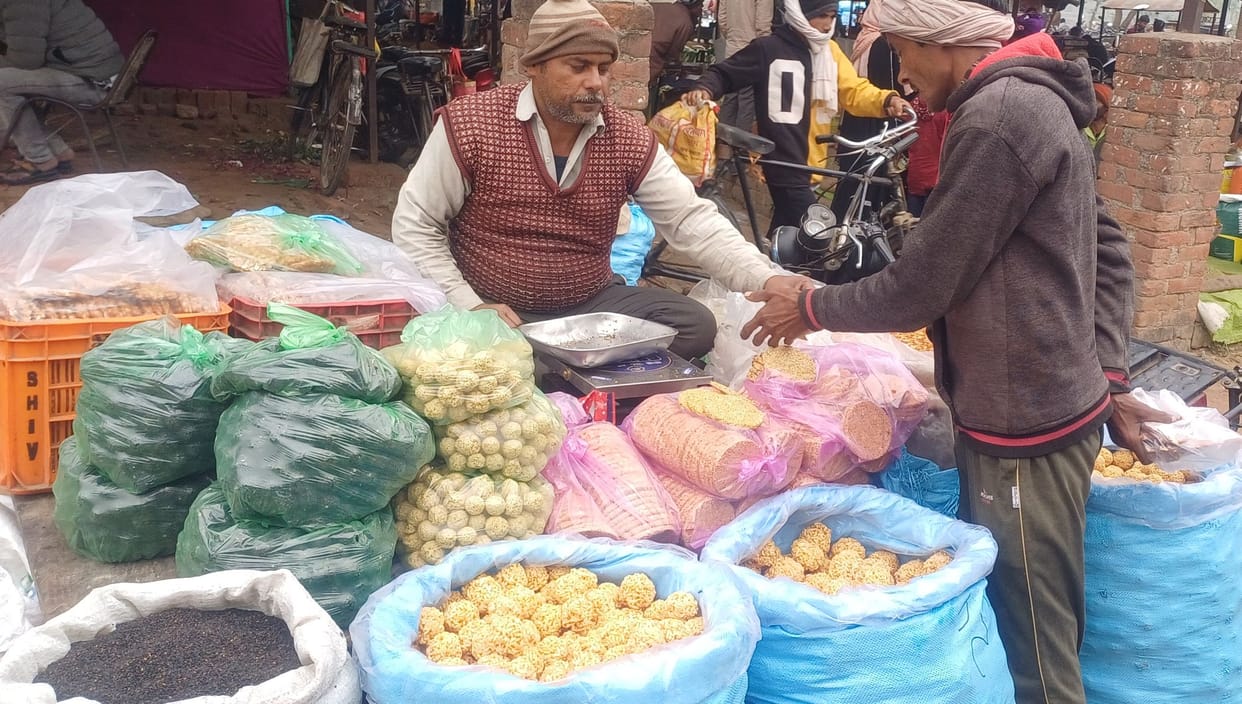The market is filled with the sweet aroma of jaggery and sesame seeds
